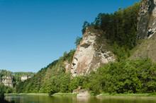 Sheer Cliff On The Banks Of A Mountain River In The Summer In The Middle Of The Day