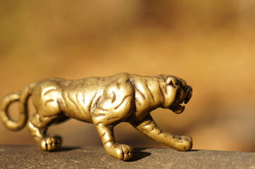 Wall Mural - Metal tiger close-up. Talismans and amulets. An esoteric symbol.