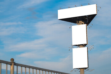 Wall Mural - mock up image: three blank white billboards or large displays on tower against blue sky with clouds.