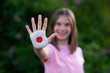 © Svetlana - Kid girl show stop gesture with hands painted in Japan flag colors. Reopen school, Healthcare. Education abroad. Learn Japanese. Selective focus