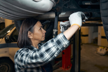 Wall Mural - Focused car technician fixing problems in a vehicle