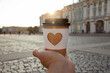 © ksenija1803z - paper cup of natural coffee with carved white heart in women's hand on Palace Square in St. Petersburg on sunset