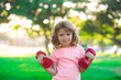 © Volodymyr - Sport child boy with strong biceps muscles. Kids exercising fitness dumbbells. Strong little boy exercising with dumbbell in park.