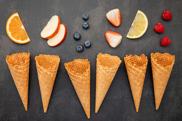Fototapete - Flat lay ice cream cones collection on dark stone background . Blank crispy ice cream cone with copy space for sweets menu design.