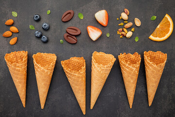 Fototapete - Flat lay ice cream cones collection on dark stone background . Blank crispy ice cream cone with copy space for sweets menu design.
