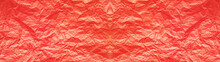 しわくちゃな赤色の花紙のテクスチャー。横に長いパノラマの背景素材。