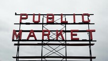 An Isolated Shot Of The Public Market Neon Metal Sign With An Overcast Sky In The Background At The Famous Pike Place Market In Seattle, Washington