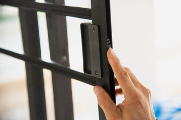 Man doing aluminum frame with glasses and wire screen door and window installation work in construction site