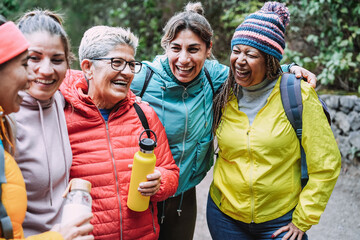 Wall Mural - Multiracial women having fun during trekking day in to the wood - Focus on african female face