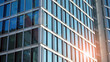 Commercial building close up in blue tone. Gigantic skyscraper from below. Architecture details of modern building amd glass facade. Business background on a beautiful sunny day. 