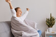 © sementsova321 - Indoor shot of happy cute girl sitting on sofa and enjoy about getting better after an illness, recovery after disease, cold or flu, healthcare, satisfied female with raised hands.