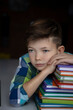 © Katsiaryna Tsiganok - sad boy and a lot of textbooks nearby