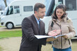 salesman with female client in campervan outlet