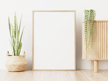 Blank Frame Mockup Standing On Wooden Floor Near Slat Sideboard And Green Snake Plant In Basket In Interior With White Wall Background. 3D Rendering, Illustration