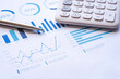 © crizzystudio - Calculator, steel pen, and financial data with graphs. The calculator and the financial report, analysis report concept