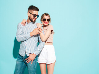 Sexy smiling beautiful woman and her handsome boyfriend. Happy cheerful family having tender moments near blue wall in studio.Pure cheerful models hugging.Embracing each other