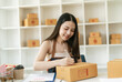 © PaeGAG - Young Asian small business owner happy with his ecommerce business preparing parcel for her online orders