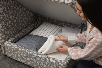 Sticker - Woman taking blanket from modular sofa section indoors