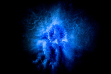 Wall Mural - Explosion of blue, navy color, fluid and neoned powder on dark studio background with copy space