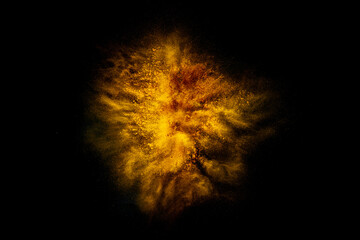 Wall Mural - Explosion of yellow, golden color, fluid and neoned powder on dark studio background with copy space
