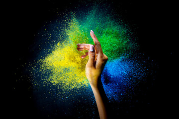 Wall Mural - Female hand and explosion of colored, neoned powder on black studio background with copy space. Magazine cover, wallpaper design