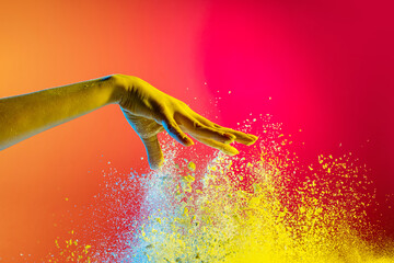 Wall Mural - Female hand and explosion of colored, neoned powder on pink studio background with copy space. Magazine cover, wallpaper design