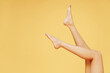 © ViDi Studio - Cropped close up photo shot of young naked european woman 20s with perfect barefoot legs isolated on plain yellow color background studio portrait. People female beauty bodycare healthcare concept