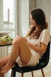 © dsheremeta - Woman eating salad while sitting by laptop in kitchen - stock photo