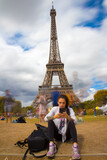 Fototapeta Paryż - Handy schauen vor dem eifelturm in paris. menschen sind nur als geister dargestellt 