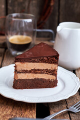 Sticker - piece of cake with coffee on a wooden background, side view