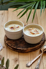 Sticker - Baked porridge with cream. Side view, wooden background