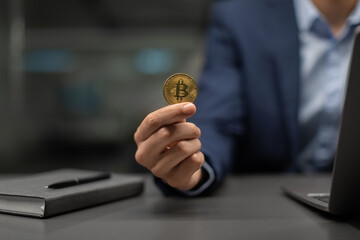 Poster - Unrecognizable businessman in suit showing bitcoin, working on laptop