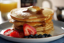 Stack Of Pancakes With Syrup And Butter And Fruits