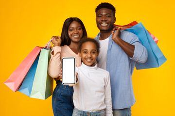 Shopping. Black family showing blank empty smartphone screen for mockup