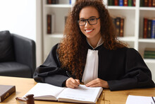 Female Judge Sitting At Workplace In Courtroom