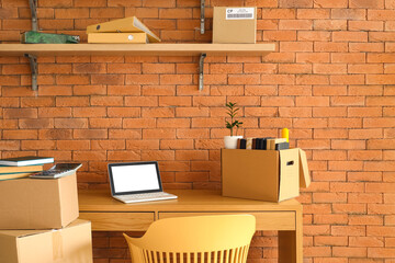 Wall Mural - Cardboard boxes with belongings and table in office on moving day