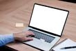 © Ratchapon - Businessman put your hand on keyboard and white screen background mock up on display laptop with clipping path