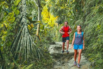 Wall Mural - Hawaii hiking hikers on Kalalau trail hike walking in rainforest with tropical trees. Tourists couple with backpacks walking outdoor in Kauai island. Summer travel adventure active lifestyle.