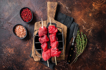 Wall Mural - Lamb shish kebab, Raw meat Skewers with herbs on grill. Dark background. Top view