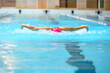 Swimmer swimming butterfly stroke alone in an empty swimming pool