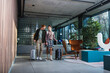 © LIGHTFIELD STUDIOS - Smiling couple with suitcases talking in hotel lobby