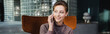 © LIGHTFIELD STUDIOS - Young woman talking on cellphone in hotel lobby, banner