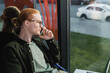 © LIGHTFIELD STUDIOS - Side view of young freelancer talking on smartphone near laptop in hotel