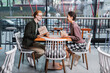 © LIGHTFIELD STUDIOS - Young couple holding gifts near glasses of wine in hotel cafe