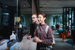 © LIGHTFIELD STUDIOS - Positive woman with backpack standing near boyfriend on hotel reception
