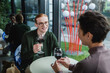© LIGHTFIELD STUDIOS - Smiling red haired man holding glass of wine near blurred girlfriend in hotel