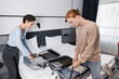 © LIGHTFIELD STUDIOS - Side view of smiling couple unpacking suitcases in hotel room