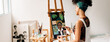 © (JLco) Julia Amaral - Young female painter working on a portrait painting in her studi