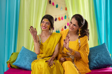 Mother And Daughter Showing Their Palms Paint With Mehndi On Haldi Ceremony