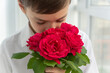 © Anna - Close up image of boy in white shirt with bouquet of red roses, greetings concept, valentines day, mothers day, little gentleman